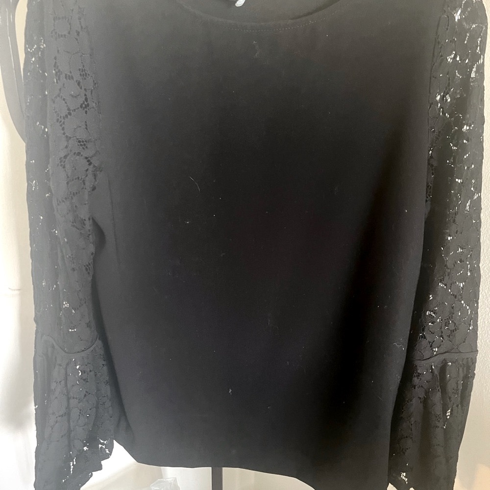 Karen Kane from Bloomingdale’s black (polyester) top with lace sleeves.
